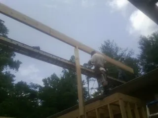 Carpenter setting a ridge beam over a new addition frame — Ice Dam Removal by Roofing Brothers in Finleyville
