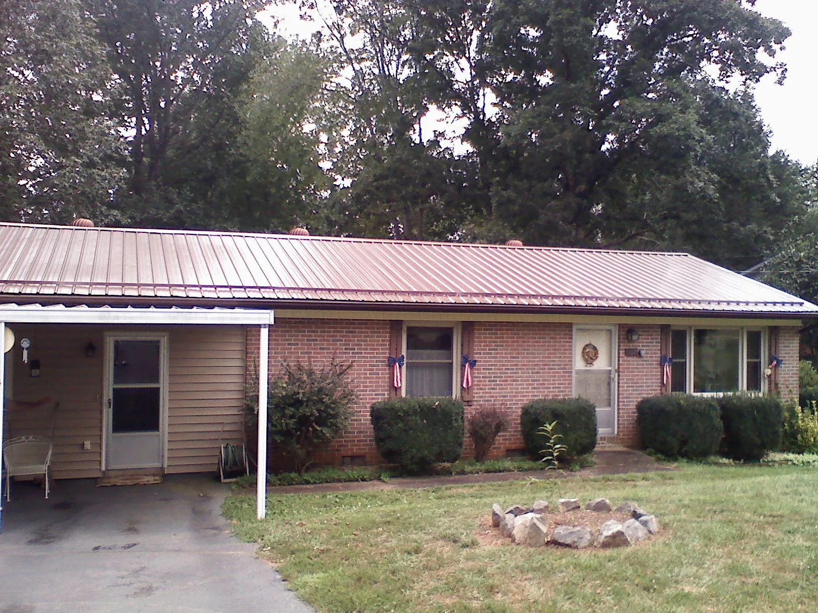 Bronze metal roof and carport on a brick ranch home — Roof Repair work by our crew in Finleyville